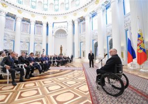 En esta foto de archivo dle 24 de marzo de 2014, Sir Philip Craven, presidente del comité paraolímpico internacional, derecha, habla frente al presidente ruso Vladimir Putin, centro atrás, en una ceremonia en el Kremlin en Moscú. Toda la delegación paraolímpica de Rusia fue vetada de los Juegos Paraolímpicos de Río de Janeiro el domingo, 7 de agosto de 2016. (Alexei Druzhinin, Sputnik, Kremlin Pool Photo via AP, file)