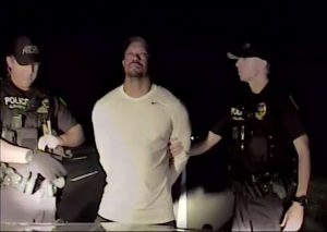 In this image taken from video golfer Tiger Woods stands between two police officers in Jupiter Florida Monday May 29,2017. Police in the US state of Florida have released video of professional golfer Tiger Woods' recent arrest. Jupiter Police released the dash-cam footage of the incident late on Wednesday May 31, 2017. Officers on patrol early on Monday noticed a Mercedes pulled awkwardly to the side of the road with the engine running, the brake lights on and a right indicator blinking. (Jupiter Police Department/via AP)