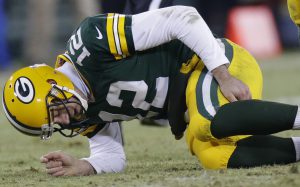 Green Bay Packers quarterback Aaron Rodgers grabs his legs after being hit by Detroit Lions defensive tackle Ndamukong Suh during the third quarter of their game Sunday, December 28, 2014 at Lambeau Field in Green Bay, Wis. The Green Bay Packers beat the Detroit Lions 30-20 to win the NFC North and a first round bye in the playoffs.  MARK HOFFMAN/MHOFFFMAN@JOURNALSENTINEL.COM