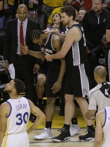 Kawhi Leonard, centro a la izquierda, de los Spurs de San Antonio, es acompañado por el pivoote español Pau Gasol en la segunda mitad del primer partido de la final de la Conferencia Oeste ante los Warriors de Golden State, en Oakland, California, el domingo 14 de mayo de 2017. (AP Foto/Jeff Chiu)